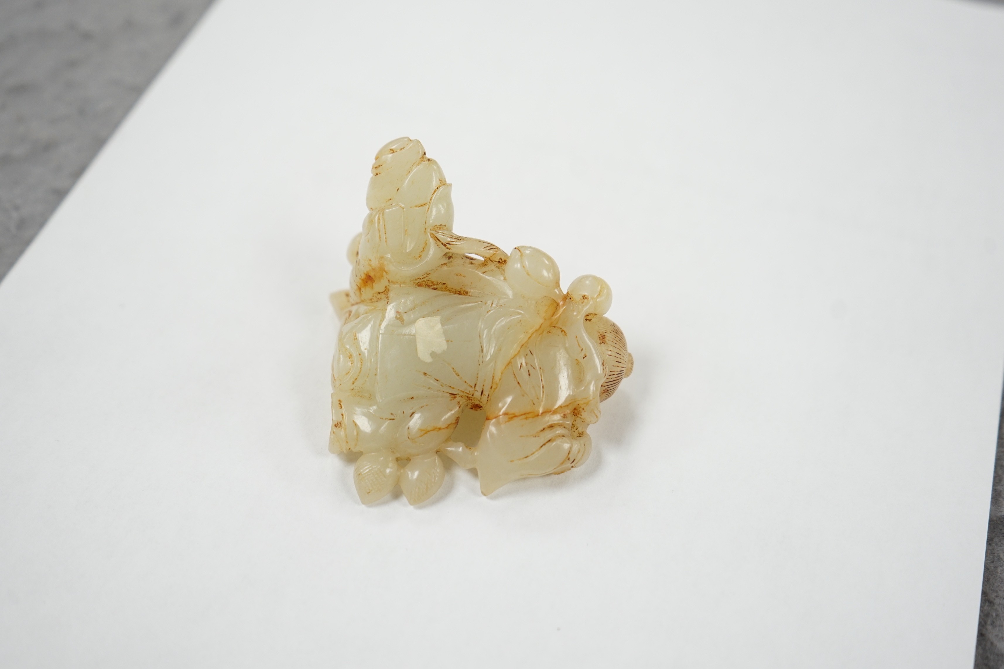 A Chinese white and russet jade group of three boys, 18th/19th century, 7.2 cm, wood stand